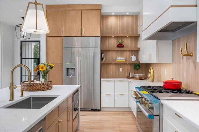9 Ogrady Ct, Orangeburg, NY 10962 - kitchen with premium appliances, custom range hood, light wood-style flooring, light stone countertops, and decorative light fixtures