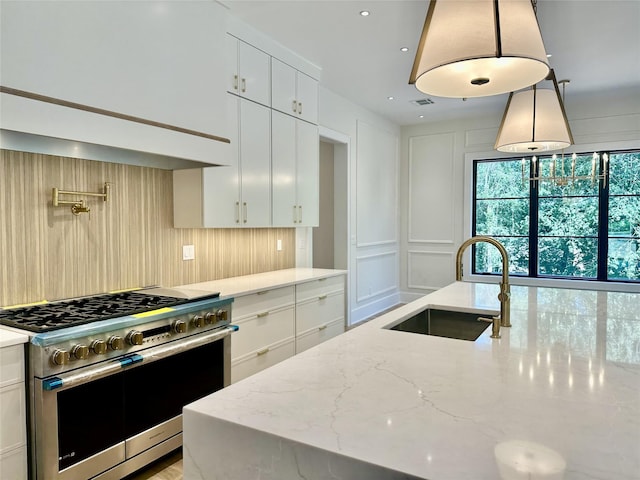 9 Ogrady Ct, Orangeburg, NY 10962 - kitchen featuring high end range, light stone countertops, a decorative wall, white cabinetry, and hanging light fixtures