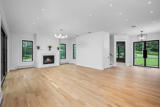 9 Ogrady Ct, Orangeburg, NY 10962 - unfurnished living room featuring a chandelier, a decorative wall, healthy amount of natural light, light wood-type flooring, and recessed lighting