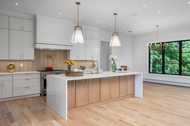 9 Ogrady Ct, Orangeburg, NY 10962 - kitchen featuring stainless steel range, light countertops, light wood-type flooring, baseboard heating, and a large island