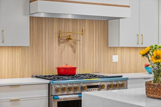 9 Ogrady Ct, Orangeburg, NY 10962 - kitchen with high end stainless steel range, custom exhaust hood, white cabinetry, and light stone counters