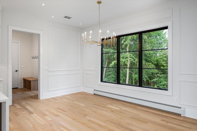 9 Ogrady Ct, Orangeburg, NY 10962 - unfurnished dining area featuring baseboard heating, a chandelier, a decorative wall, and light wood-type flooring