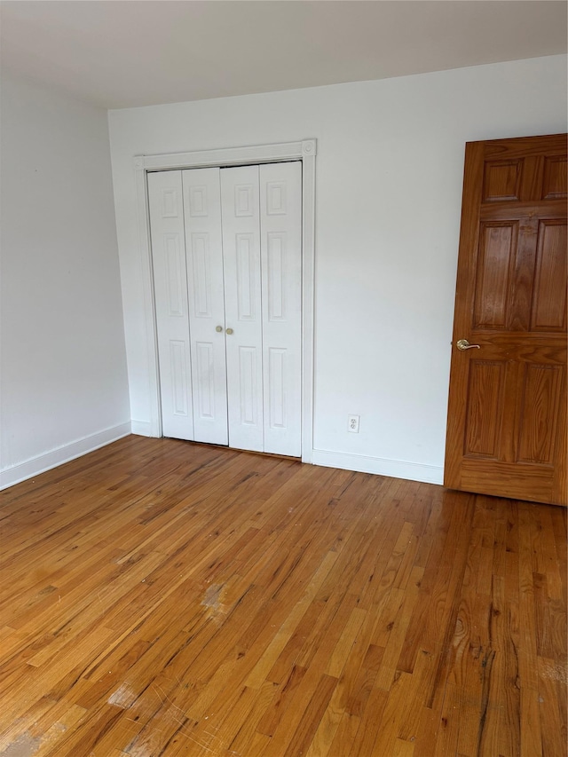 93-30 246th St, Bellerose Terrace, NY 11001 - unfurnished bedroom featuring a closet, light wood finished floors, and baseboards