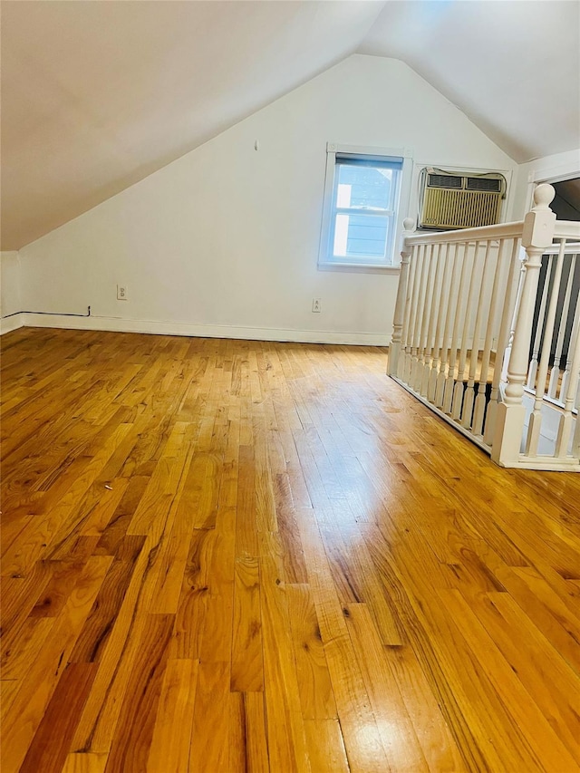 93-30 246th St, Bellerose Terrace, NY 11001 - additional living space featuring baseboards, vaulted ceiling, hardwood / wood-style flooring, and a wall mounted air conditioner