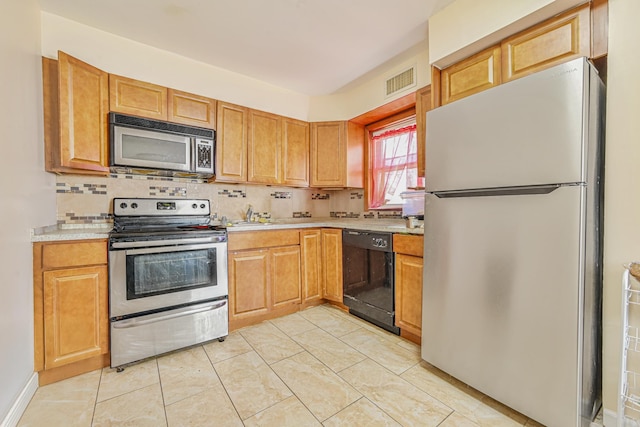 kitchen with stainless steel appliances, light countertops, backsplash, visible vents, and light tile patterned floors