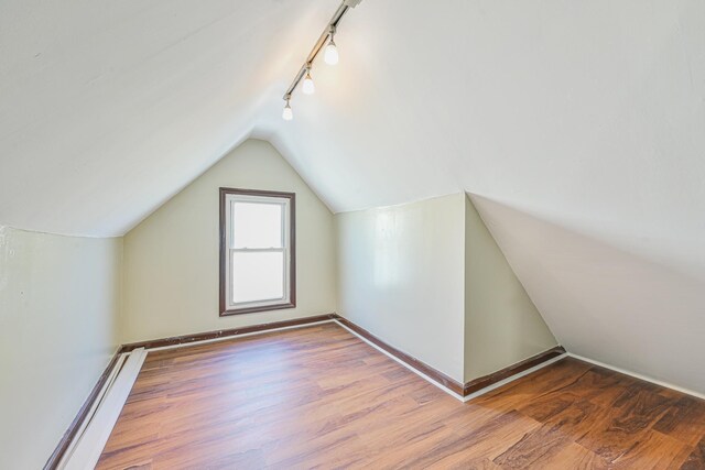 bonus room featuring vaulted ceiling, wood finished floors, and baseboards