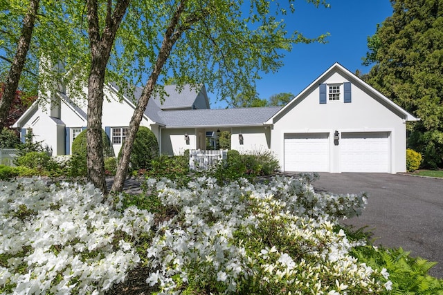 11 Morgan Ln, Locust Valley, NY 11560 - view of front of house with asphalt driveway, stucco siding, and a garage