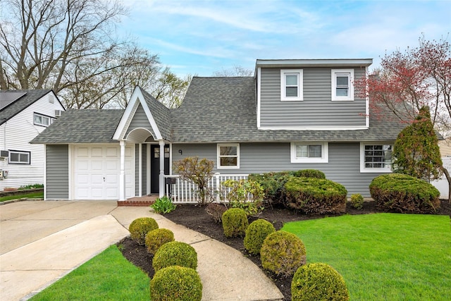 view of front facade featuring a garage, roof with shingles, a front yard, and concrete driveway