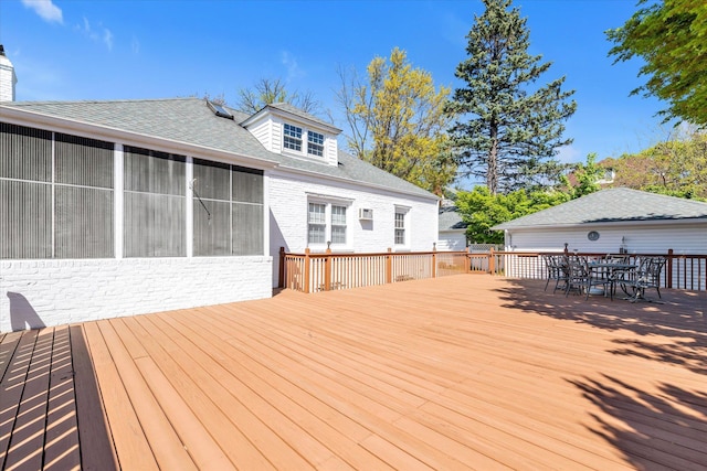 deck with outdoor dining area and a sunroom