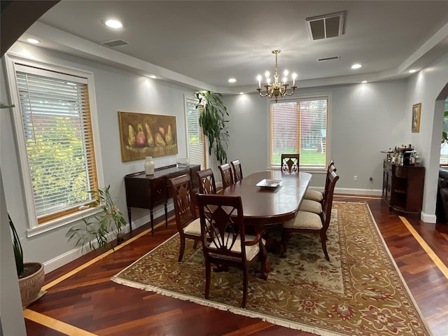 dining area featuring wood finished floors, visible vents, a wealth of natural light, baseboards, and a chandelier