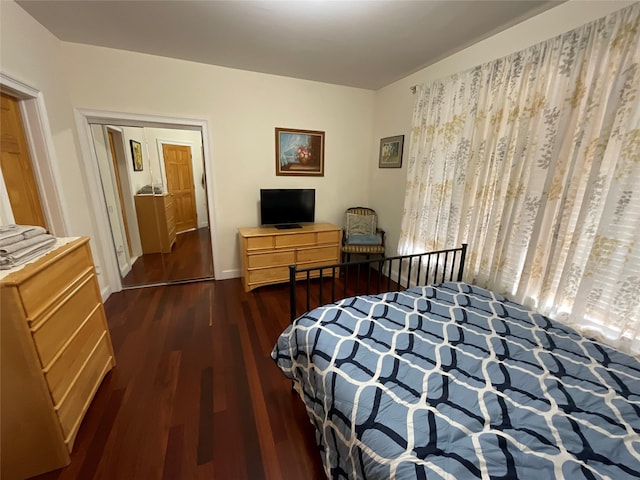 bedroom featuring dark wood finished floors and baseboards