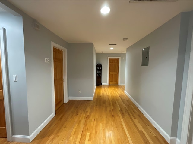 hall with recessed lighting, visible vents, light wood-style floors, electric panel, and baseboards