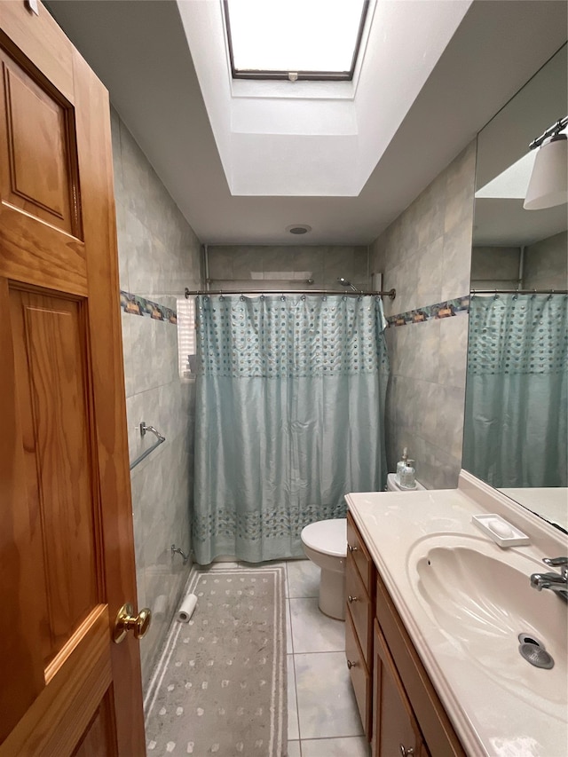 bathroom with tile patterned flooring, curtained shower, a skylight, and tile walls