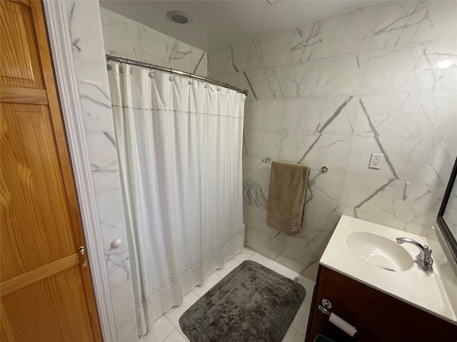 bathroom with tile walls, vanity, tile patterned flooring, and a shower with curtain