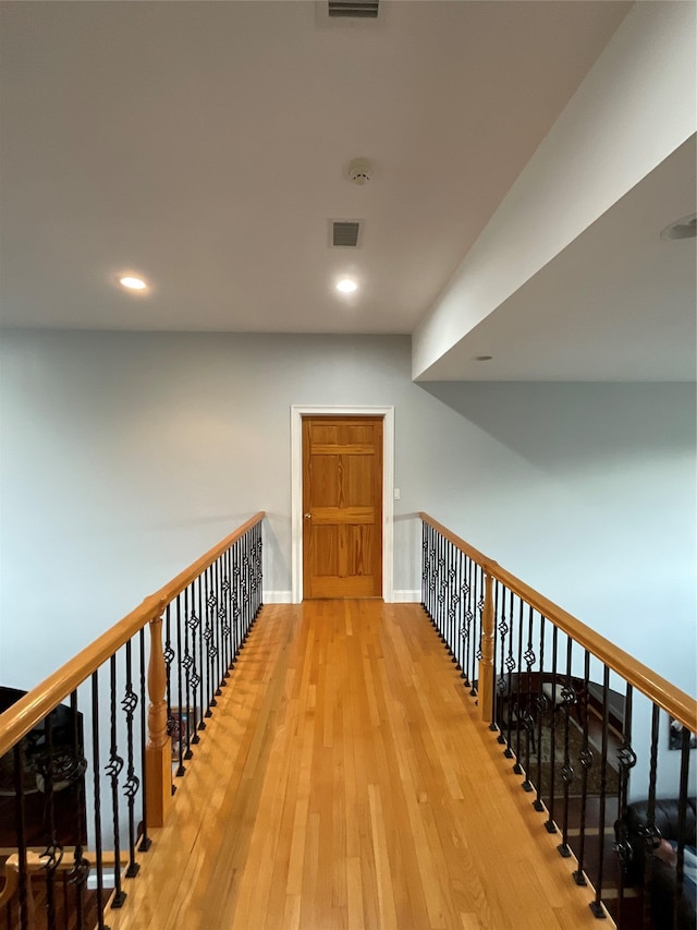 hallway featuring recessed lighting, baseboards, visible vents, and hardwood / wood-style flooring