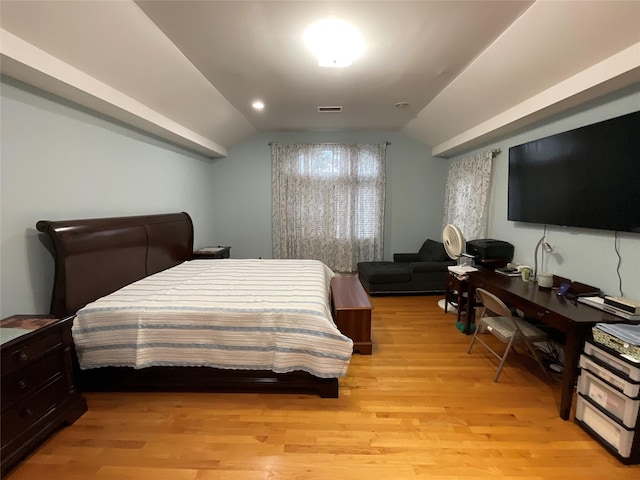 bedroom featuring vaulted ceiling, visible vents, and light wood-type flooring