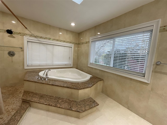 bathroom featuring a bath, tile patterned floors, and a tile shower