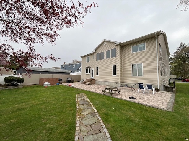 back of property with a lawn, a patio, and fence