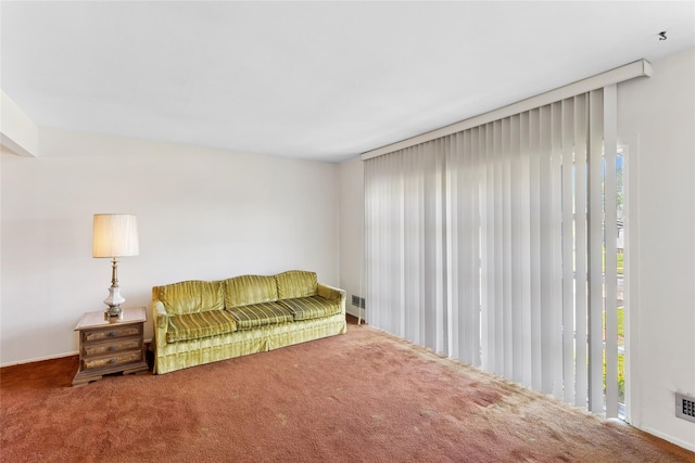 living area featuring carpet floors, visible vents, and a wealth of natural light