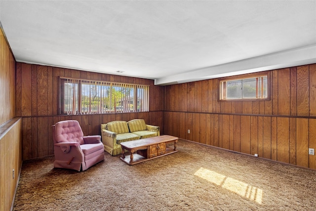 living area featuring carpet flooring and wood walls