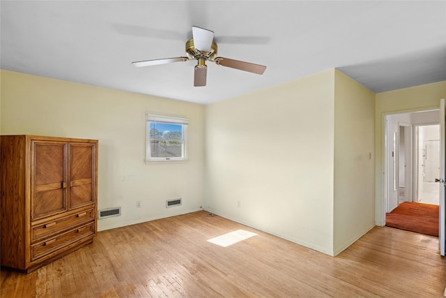 unfurnished bedroom with visible vents, light wood-style flooring, ceiling fan, and baseboards