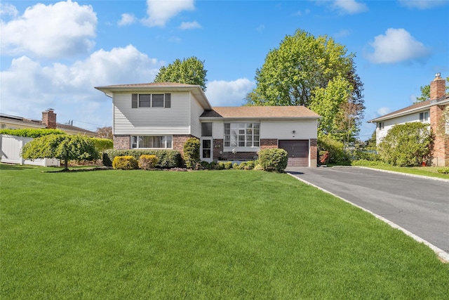 tri-level home featuring brick siding, an attached garage, driveway, and a front lawn