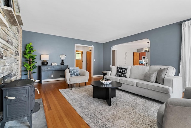 200 Fort Hill Rd, Scarsdale, NY 10583 - living room featuring arched walkways, wood finished floors, a wood stove, a chandelier, and baseboards