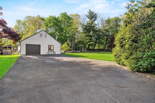 200 Fort Hill Rd, Scarsdale, NY 10583 - view of side of property featuring a detached garage, an outdoor structure, a lawn, asphalt driveway, and a chimney