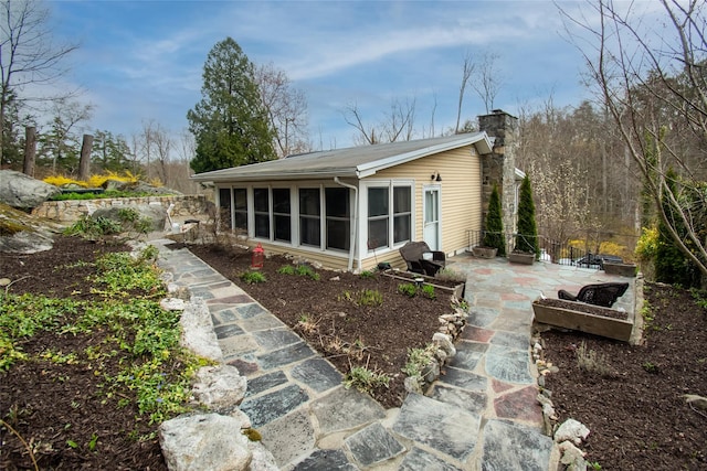25 Evergreen Rd, Putnam Valley, NY 10579 - rear view of house featuring a patio area, a chimney, and a sunroom