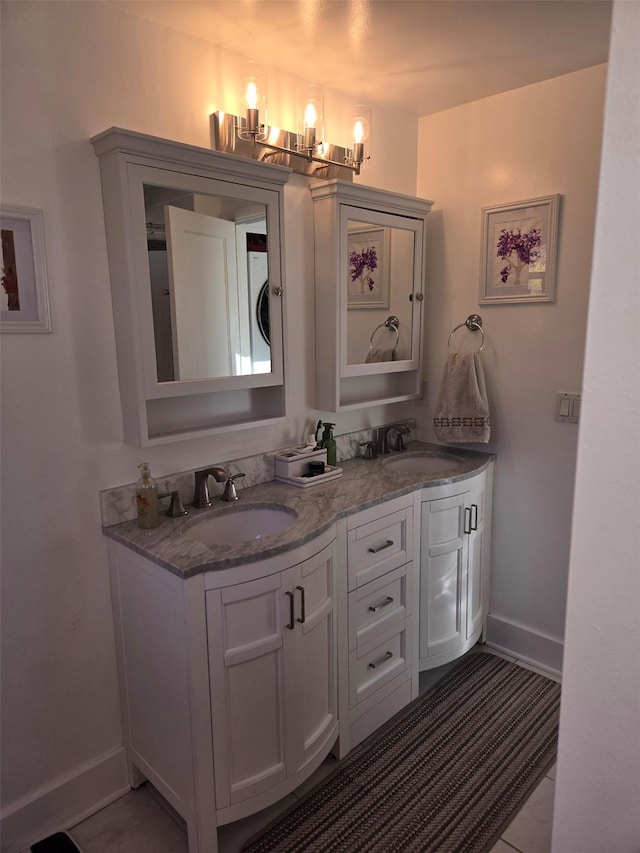 25 Evergreen Rd, Putnam Valley, NY 10579 - bathroom with baseboards, a sink, double vanity, and an inviting chandelier