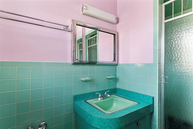 bathroom featuring tile walls, a wainscoted wall, vanity, and a shower stall