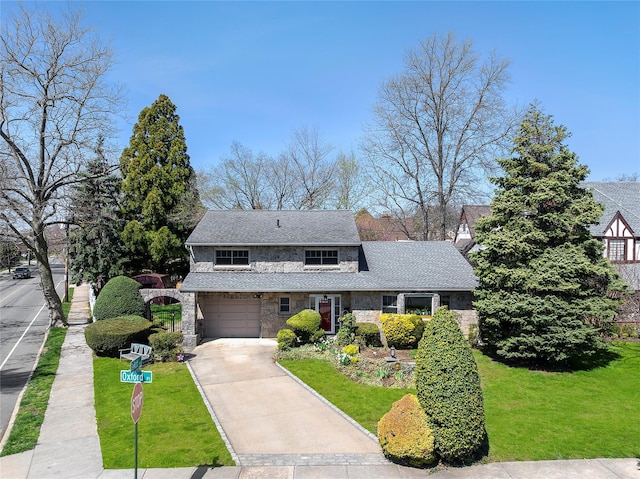 traditional-style house with an attached garage, driveway, stone siding, and a front yard
