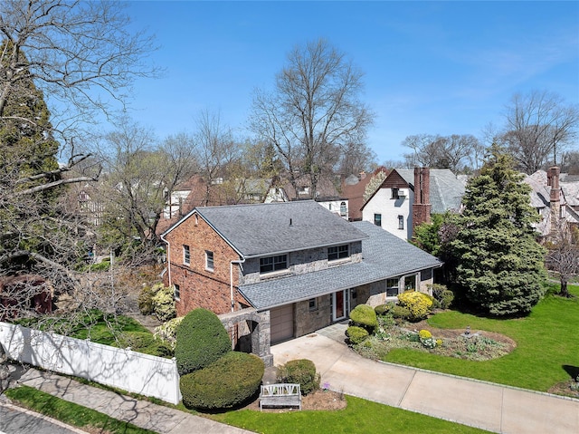 exterior space featuring concrete driveway, a chimney, stone siding, an attached garage, and a front yard