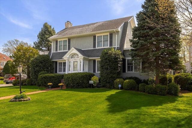 169 Hempstead Ave, Rockville Centre, NY 11570 - view of front of home featuring a chimney, roof with shingles, and a front yard