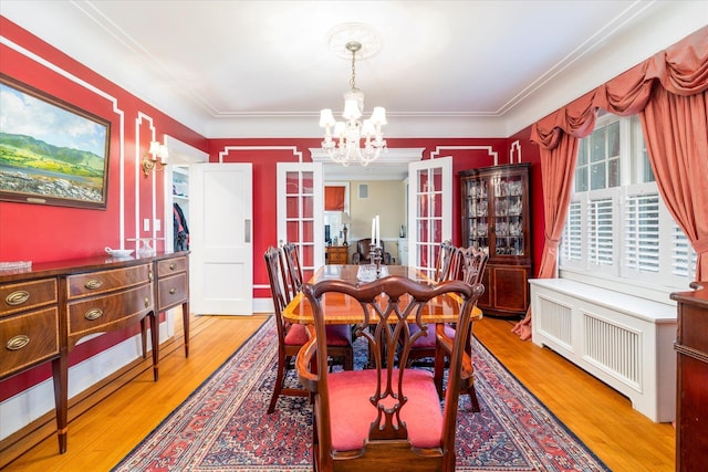 169 Hempstead Ave, Rockville Centre, NY 11570 - dining room featuring french doors, wood finished floors, a chandelier, and radiator