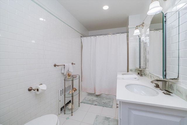 169 Hempstead Ave, Rockville Centre, NY 11570 - bathroom featuring a sink, double vanity, toilet, tile walls, and tile patterned flooring