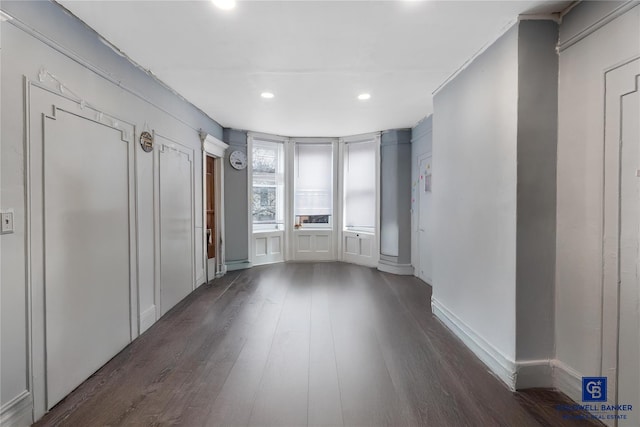 interior space with baseboards, dark wood-type flooring, and recessed lighting