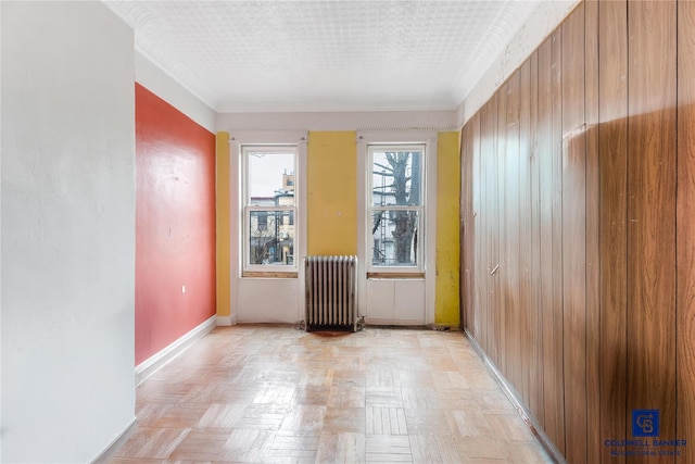 unfurnished room with baseboards and radiator