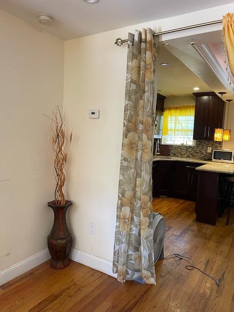 1255 E 223rd St, Bronx, NY 10466 - interior space with decorative backsplash, wood finished floors, baseboards, light countertops, and stainless steel microwave