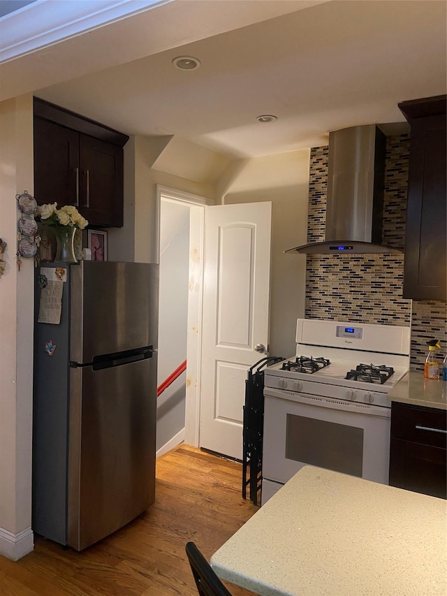 1255 E 223rd St, Bronx, NY 10466 - kitchen featuring wall chimney range hood, tasteful backsplash, freestanding refrigerator, white gas range, and light wood-style floors