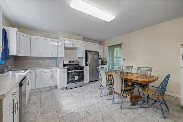 kitchen featuring a sink, white cabinetry, light countertops, and appliances with stainless steel finishes