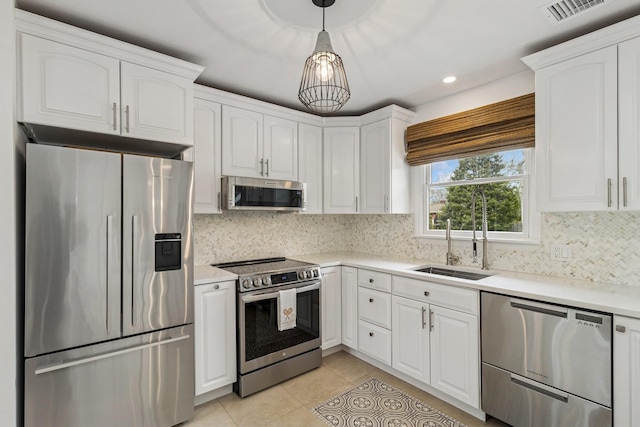 kitchen with stainless steel appliances, a sink, visible vents, white cabinetry, and light tile patterned floors