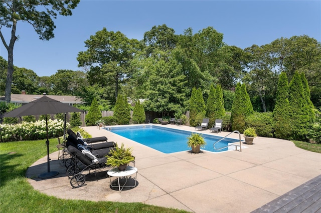 outdoor pool with fence and a patio area