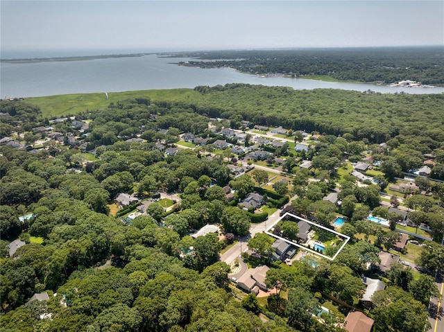 drone / aerial view featuring a wooded view and a water view