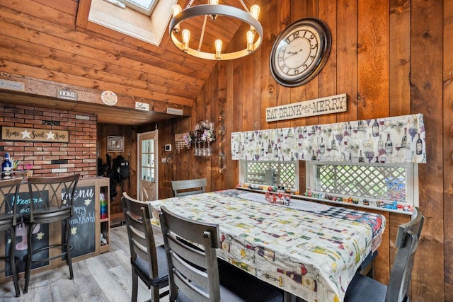 dining area featuring wood finished floors, wooden ceiling, wood walls, and an inviting chandelier