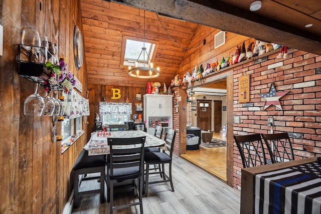 dining room featuring wooden walls, wood finished floors, and high vaulted ceiling