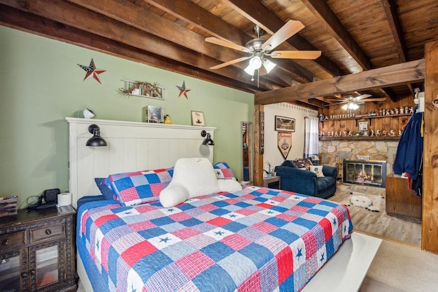 bedroom featuring wooden ceiling, wood finished floors, beam ceiling, and a fireplace