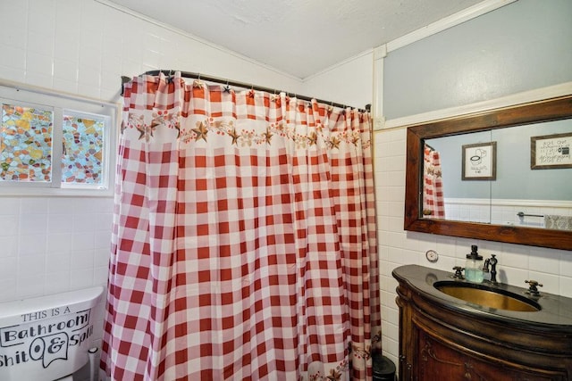 bathroom with ornamental molding, vanity, curtained shower, and tile walls