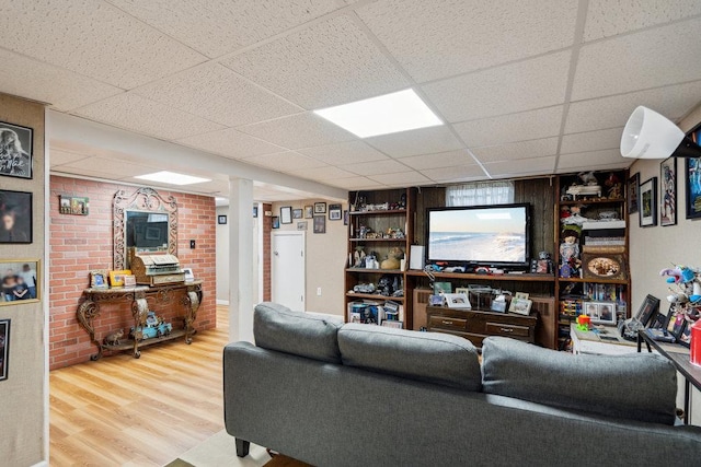living area with a paneled ceiling and wood finished floors