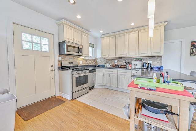 351 Bch 87th St, Rockaway Beach, NY 11693 - kitchen featuring stainless steel appliances, backsplash, cream cabinets, dark countertops, and recessed lighting